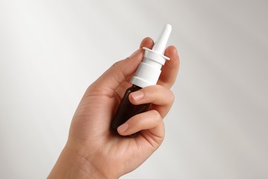 Photo of Woman with nasal spray on white background, closeup