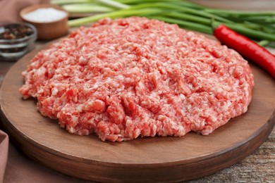 Photo of Board with raw fresh minced meat on wooden table, closeup