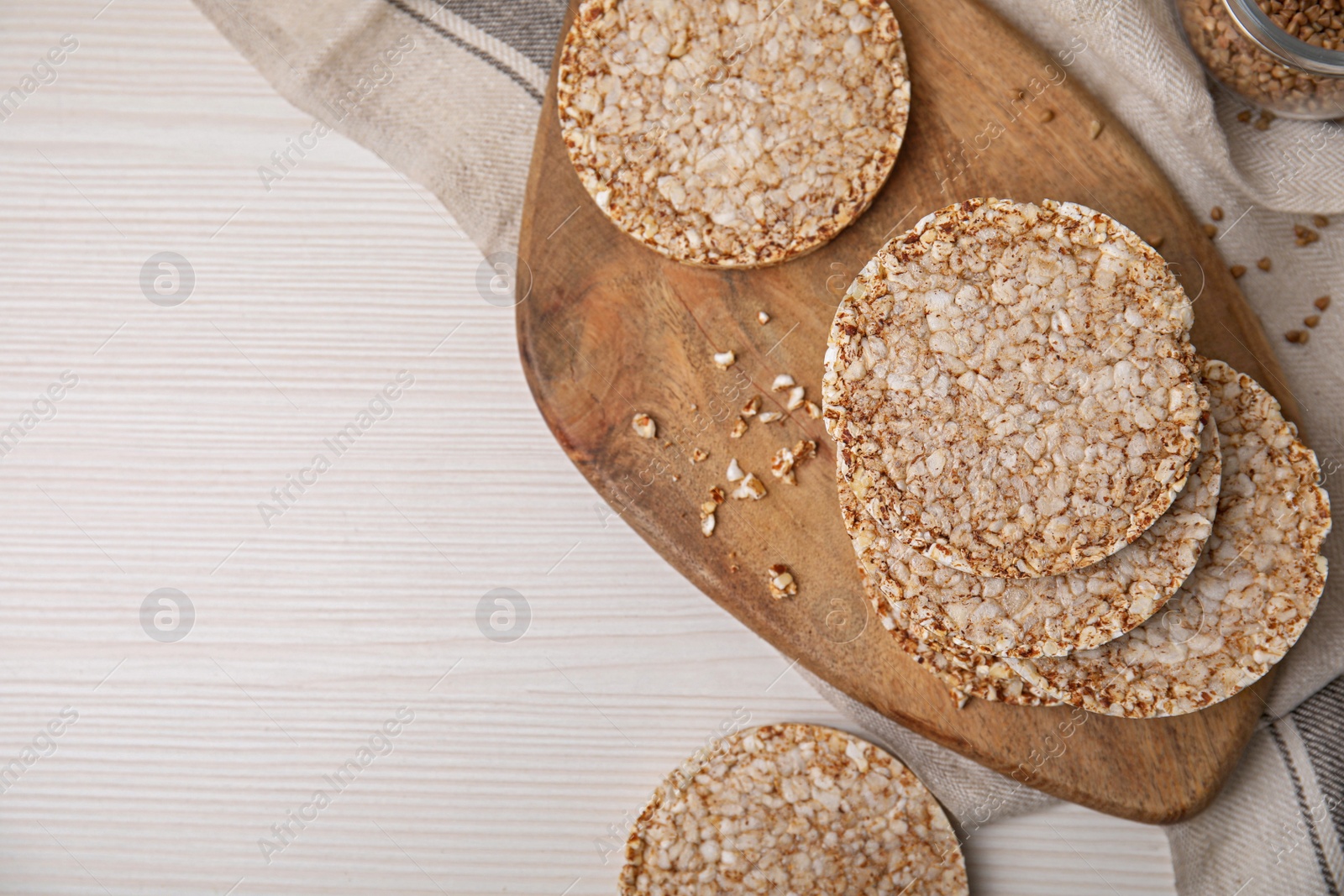 Photo of Stack of fresh crunchy rice cakes on white wooden table, flat lay. Space for text