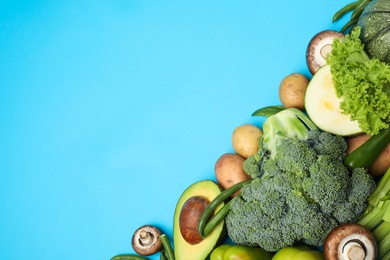 Photo of Flat lay composition with fresh vegetables on light blue background. Space for text