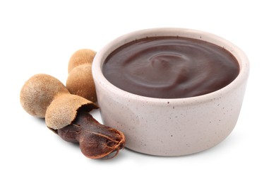 Photo of Bowl of tamarind sauce and fresh pods isolated on white