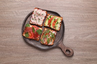 Photo of Different tasty sandwiches on wooden table, top view