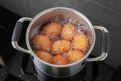 Photo of Chicken eggs boiling in pot on electric stove, above view
