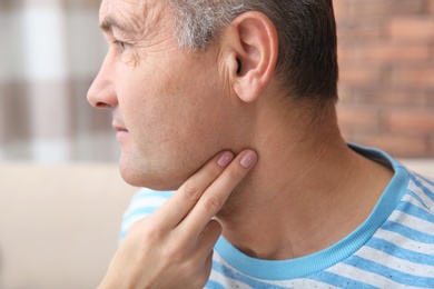 Photo of Young woman checking mature man's pulse with fingers indoors