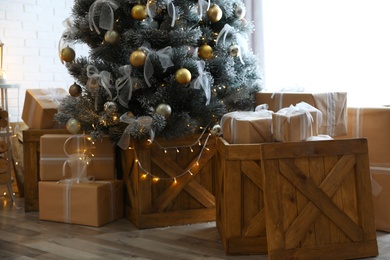 Photo of Decorated Christmas tree and gift boxes In elegant room interior