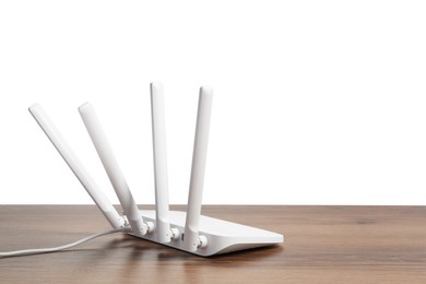 Photo of New modern Wi-Fi router on wooden table against white background. Space for text