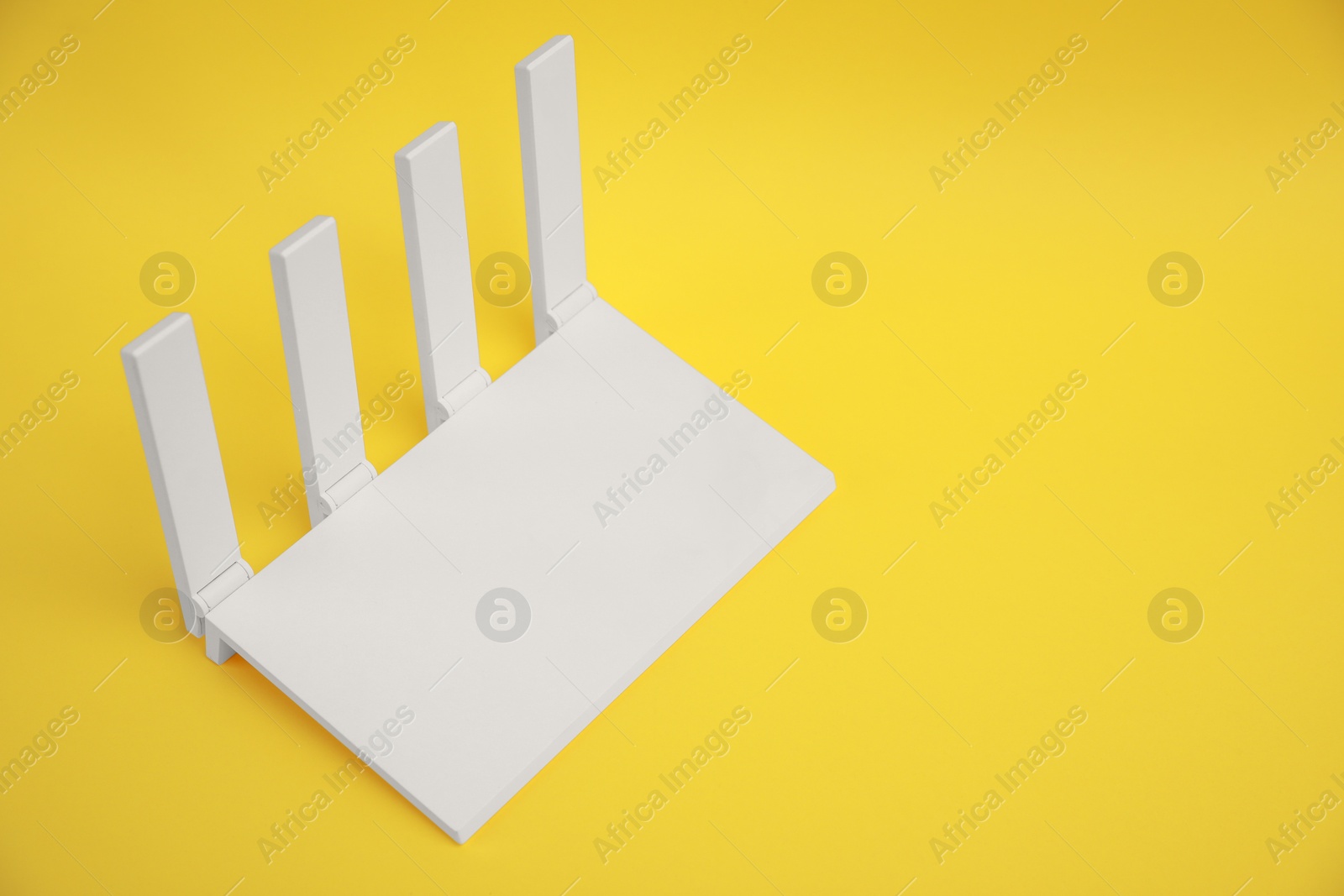 Photo of Modern Wi-Fi router on yellow background. Space for text