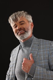 Photo of Portrait of smiling man with beautiful hairstyle on black background