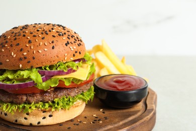 Photo of Burger with delicious patty, french fries and sauce on light table, closeup