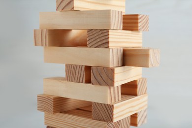 Photo of Jenga tower made of wooden blocks on white background, closeup