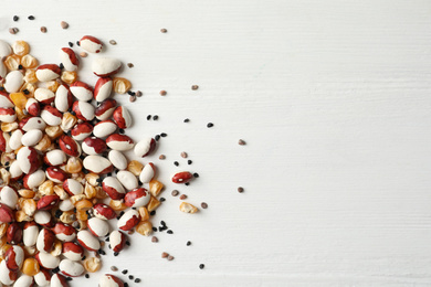 Photo of Mixed vegetable seeds on white wooden background, flat lay. Space for text