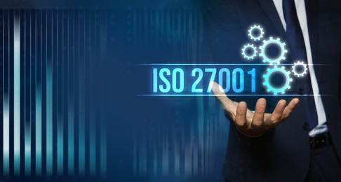 Image of Man demonstrating virtual icon with text ISO 27001, closeup. Banner design
