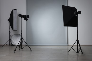 Modern light grey photo background and professional lighting equipment in studio