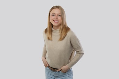 Photo of Portrait of beautiful young woman in stylish sweater on white background