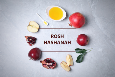 Frame of honey, apples and pomegranates on marble table, flat lay. Rosh Hashanah holiday