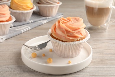 Photo of Tasty cupcake with cream served on wooden table