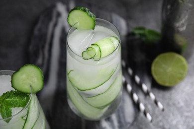 Photo of Refreshing cucumber water on dark grey table, closeup