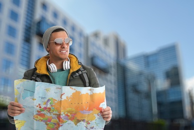 Image of Happy traveler with map in foreign city. Vacation trip