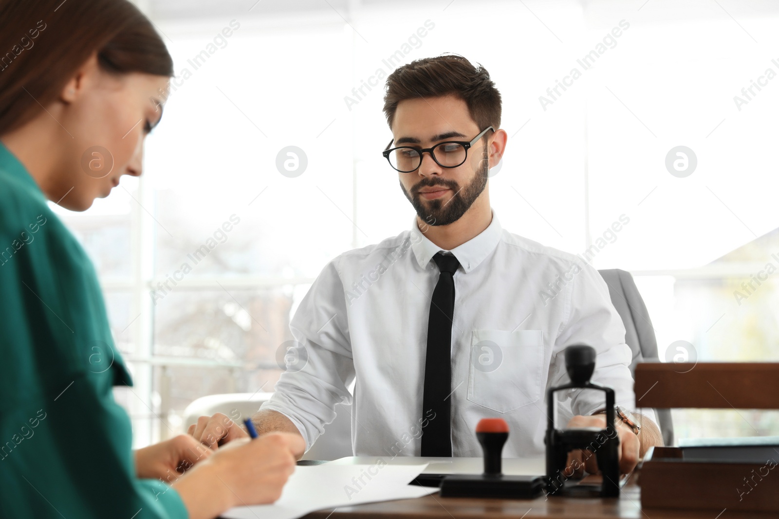 Photo of Male notary working with client in office