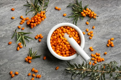 Photo of Fresh ripe sea buckthorn on grey table, flat lay