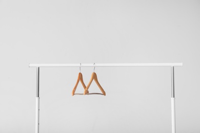 Photo of Wardrobe rack with empty hangers on white background