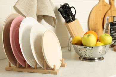 Photo of Plates, different cooking utensils and fruits on kitchen counter