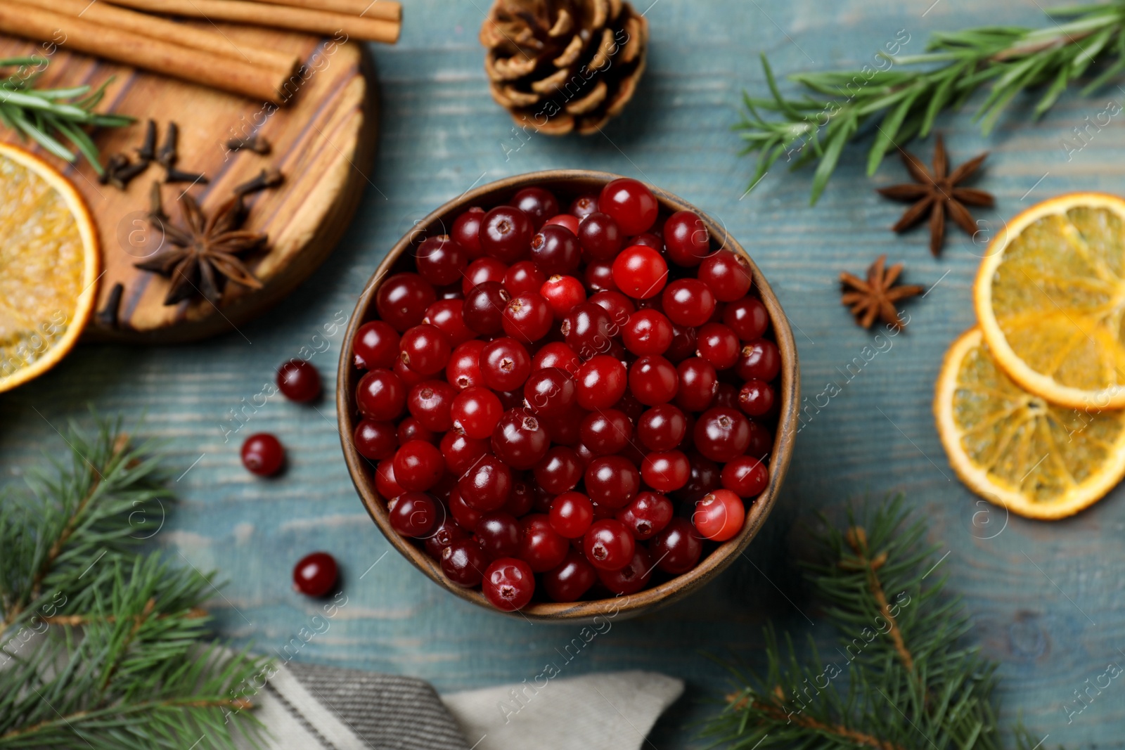 Photo of Flat lay composition with fresh ripe cranberries on blue wooden table