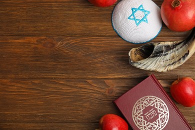 Flat lay composition with Rosh Hashanah holiday attributes on wooden table. Space for text