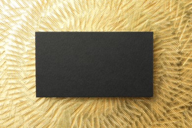 Blank business card on golden background, top view. Mockup for design
