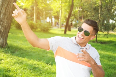 Photo of Handsome man wearing stylish sunglasses in park