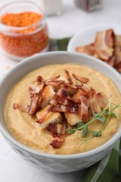 Photo of Delicious lentil soup with bacon and croutons on white table