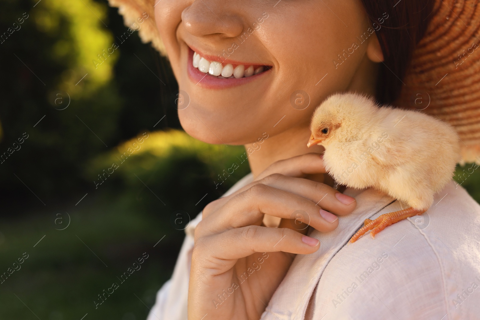 Photo of Woman with cute chick outdoors, closeup. Baby animal