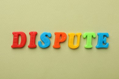 Photo of Word Dispute made of colorful letters on light green background, flat lay