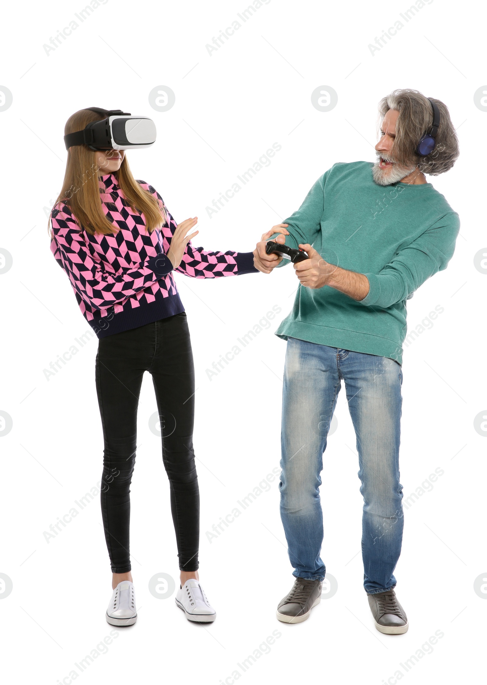 Photo of Teenage girl wearing VR headset and mature man with controller playing video games on white background