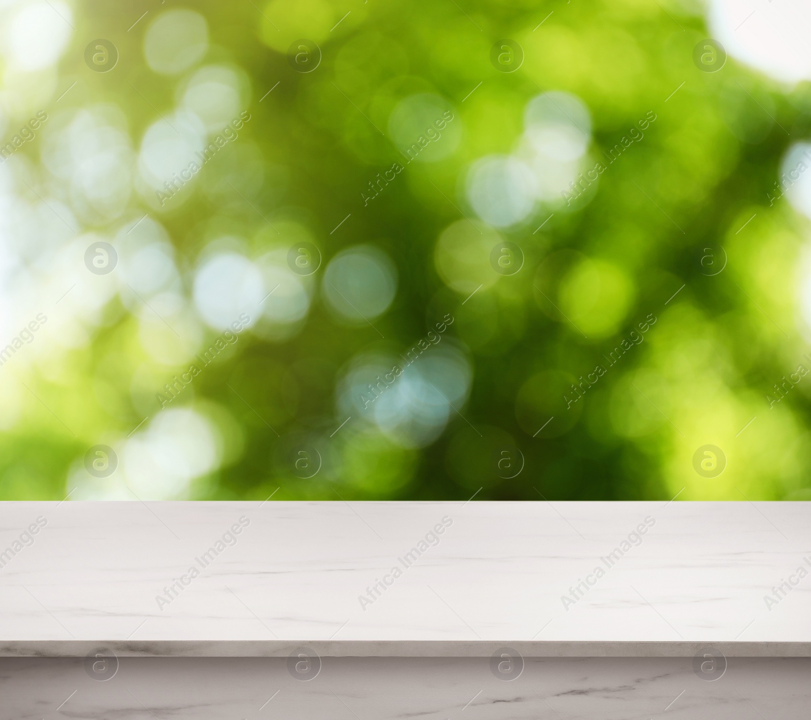 Image of Empty white marble surface against blurred green background. Space for design