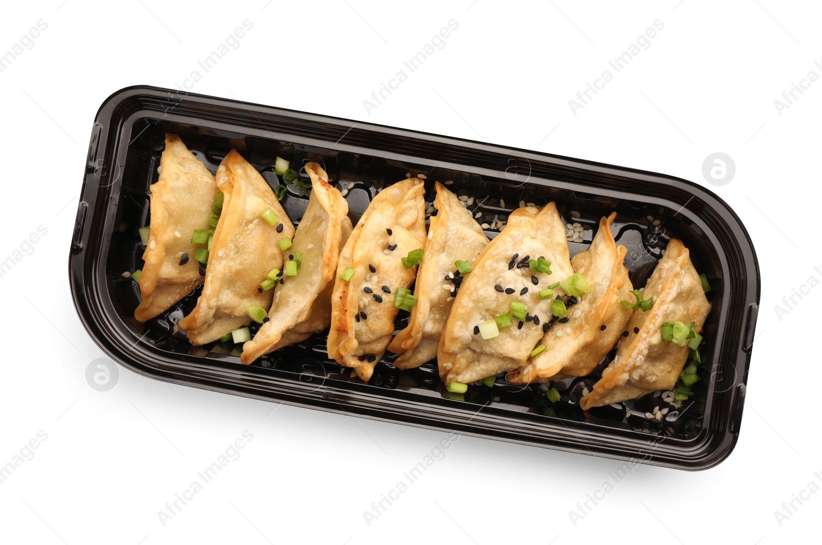 Photo of Delicious gyoza (asian dumplings) with sesame and onion isolated on white, top view