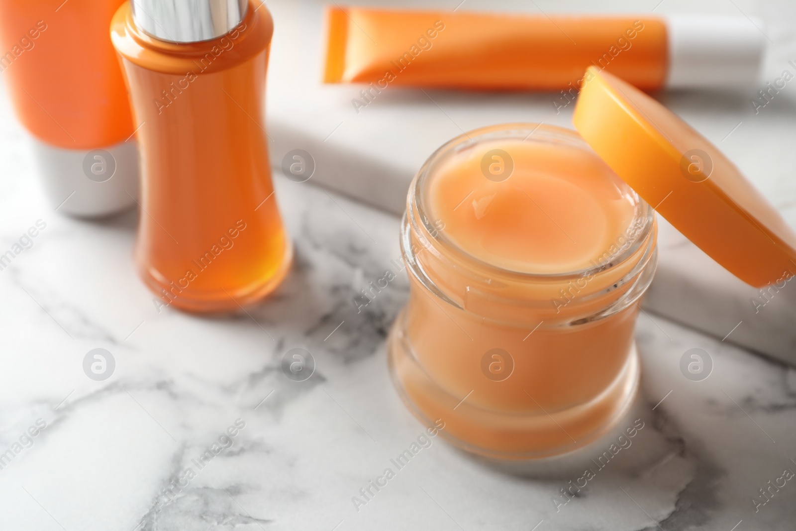 Photo of Set of luxury cosmetic products on white marble table, closeup