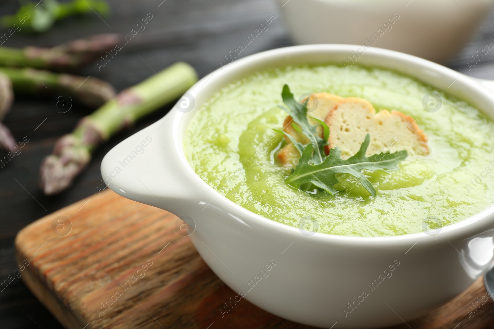 Photo of Delicious asparagus soup served on table, closeup