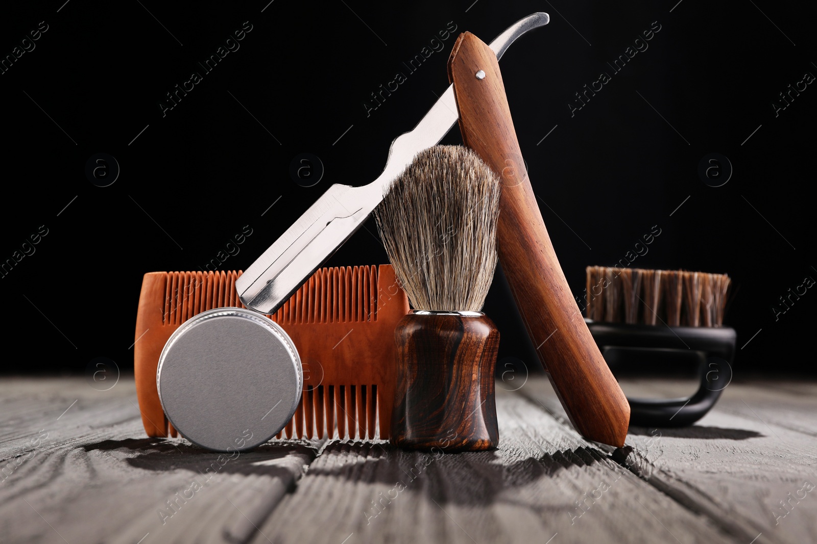 Photo of Moustache and beard styling tools on wooden table