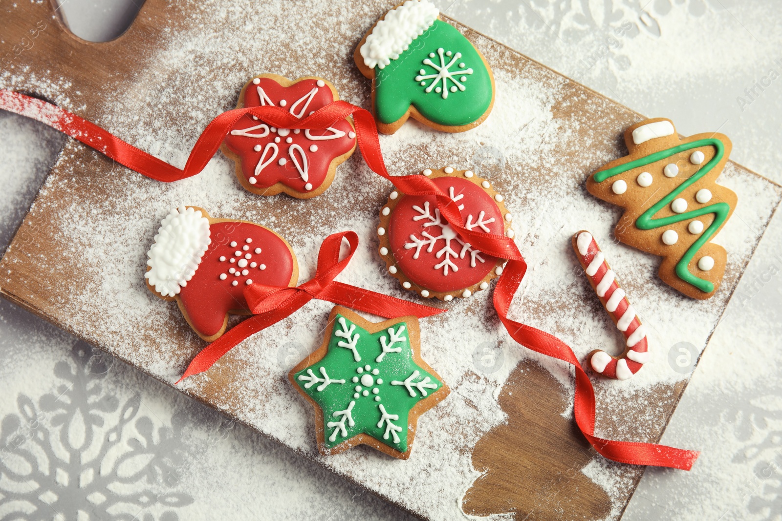 Photo of Tasty decorated Christmas cookies on wooden board, top view