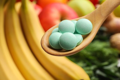 Dietary supplements in wooden spoon near products, closeup