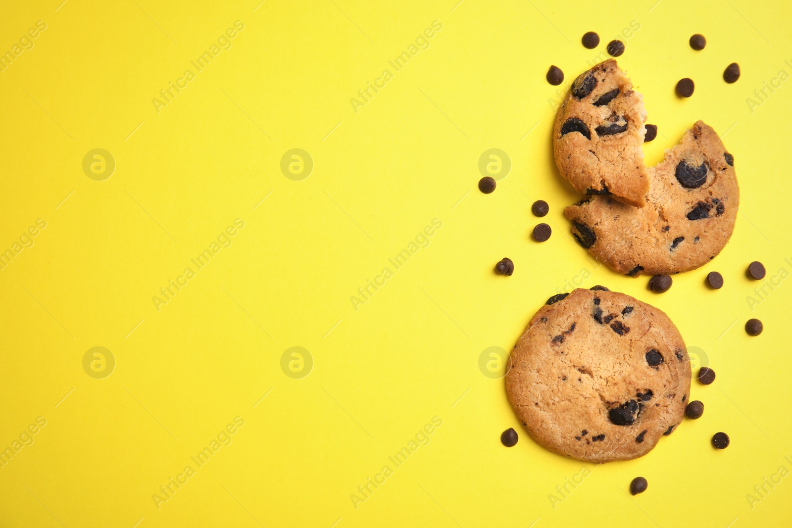 Photo of Delicious chocolate chip cookies on color background, flat lay. Space for text