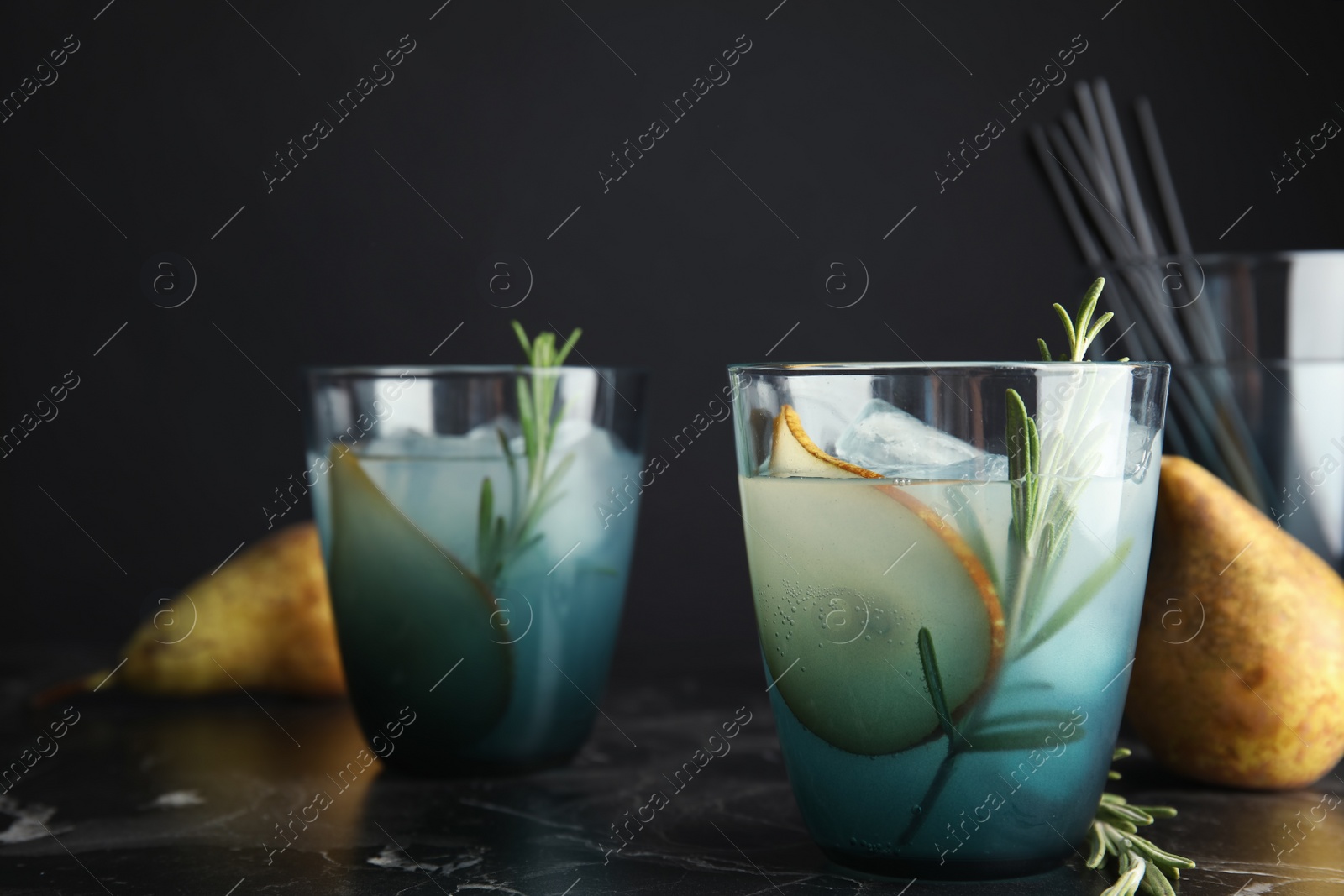 Photo of Tasty refreshing pear cocktail with rosemary on table