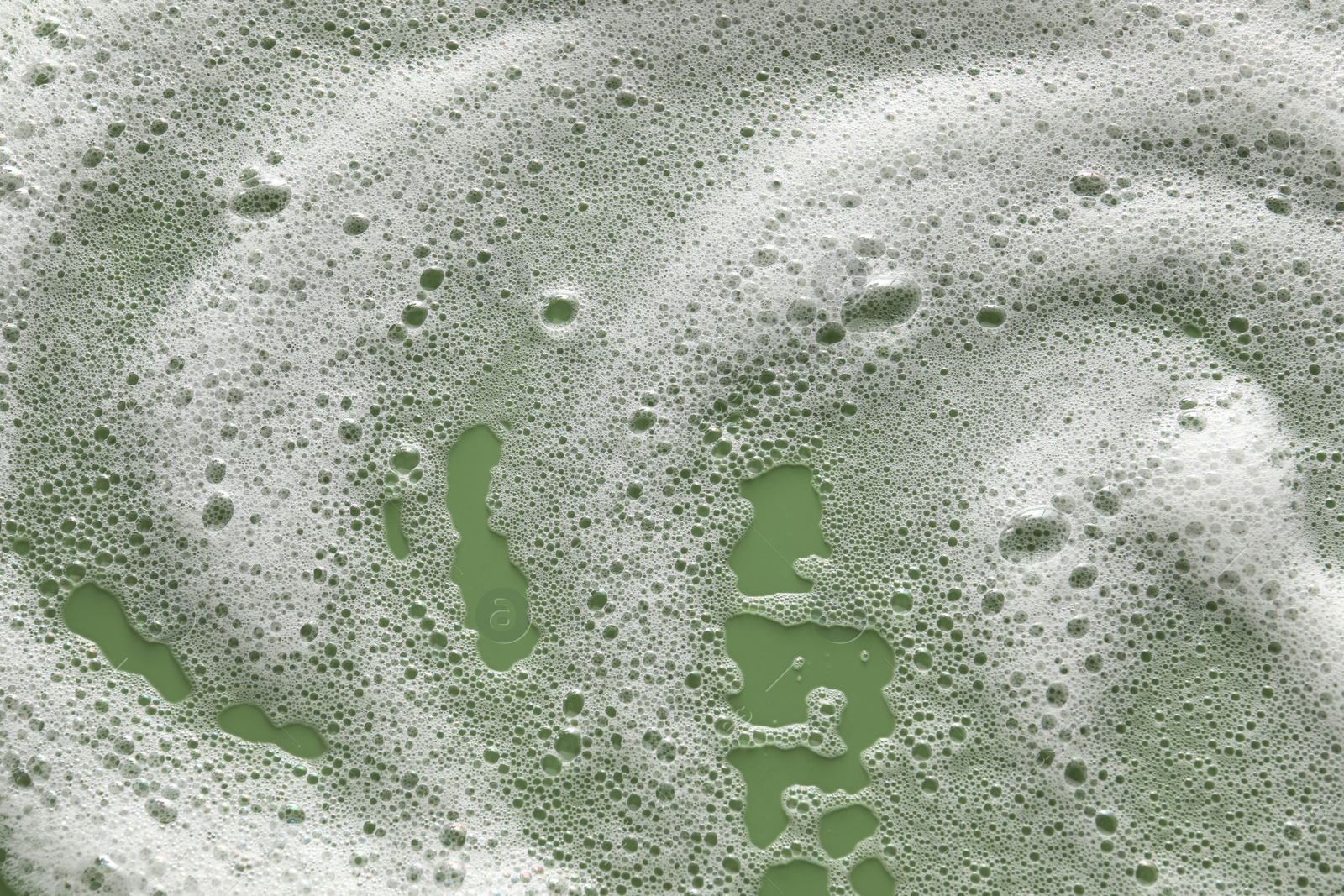 Photo of White washing foam on olive background, top view