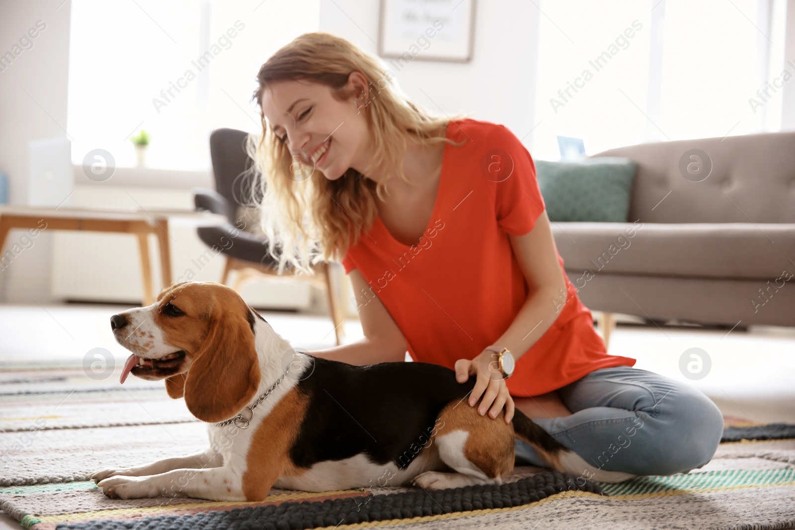 Photo of Young woman with her dog at home