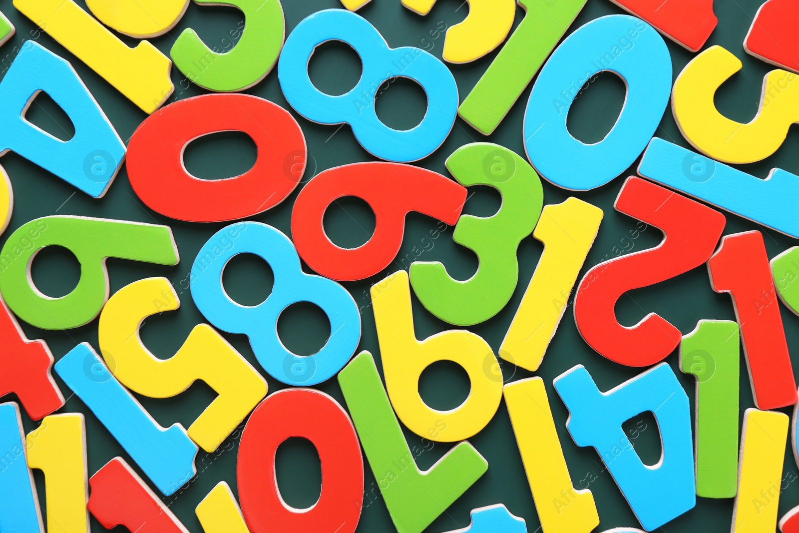 Photo of Colorful numbers on green background, top view