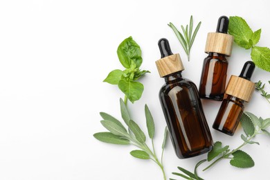 Photo of Bottles of essential oil and fresh herbs on white background, flat lay. Space for text