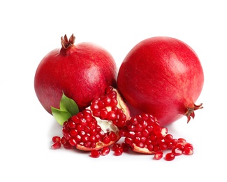 Photo of Ripe fresh pomegranates and leaves on white background