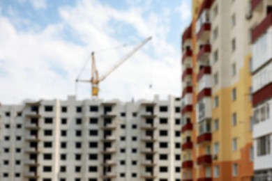 Blurred view of buildings and construction crane outdoors