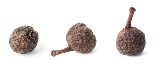 Image of Three allspice peppercorns on white background, closeup